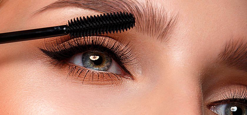 девушка красит глаза тушью