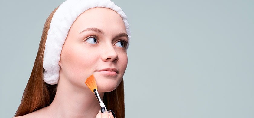 девушка с кистью для ухода за лицом