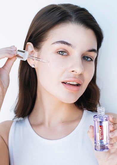 девушка наносит сыворотку для лица