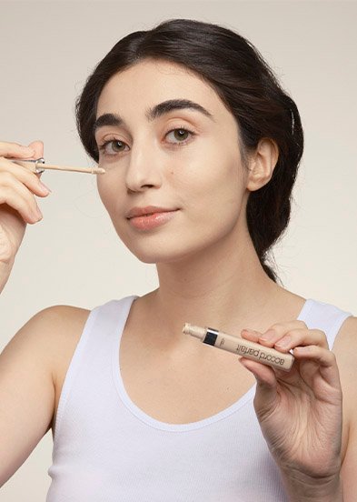 девушка наносит консилер фото